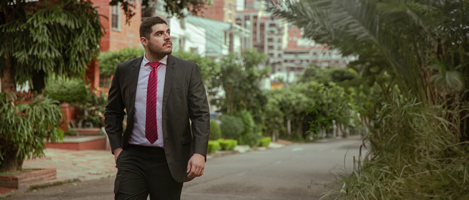 Andrés Peñaranda caminando por la calle, de saco y corbata